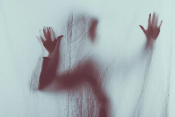 Scary blurry silhouette of person touching veil with hands — Stock Photo