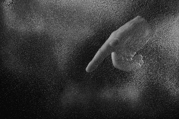 Tiro cortado de pessoa apontando para baixo com o dedo através de vidro fosco na escuridão — Fotografia de Stock