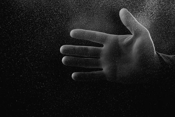 Cropped shot of person showing palm through frosted glass in darkness — Stock Photo