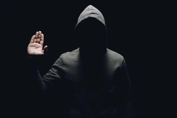 Unrecognizable man in hoodie showing palm isolated on black — Stock Photo
