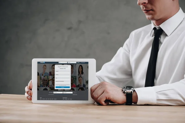 Обрезанный снимок бизнесмена с цифровым планшетом со ссылкой на сайт на экране — стоковое фото