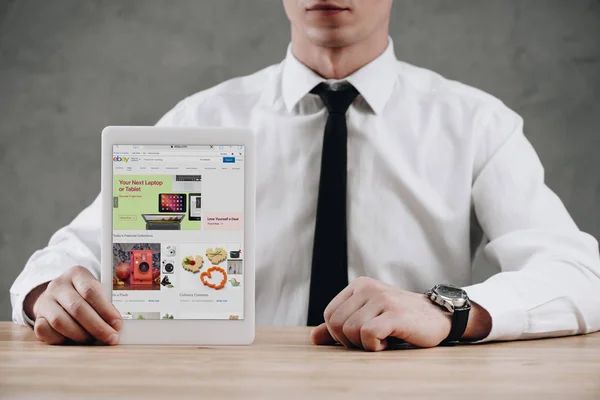 Cropped shot of businessman holding digital tablet with ebay website on screen — Stock Photo