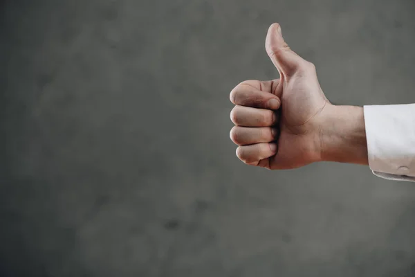 Cropped shot of man showing thumb up on grey — Stock Photo