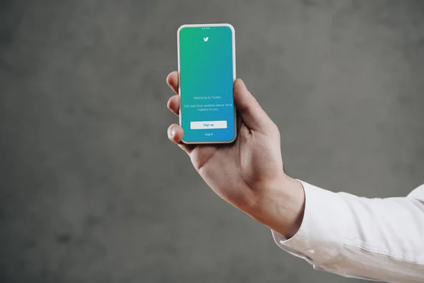 Plan recadré de l'homme tenant smartphone avec application twitter à l'écran — Photo de stock