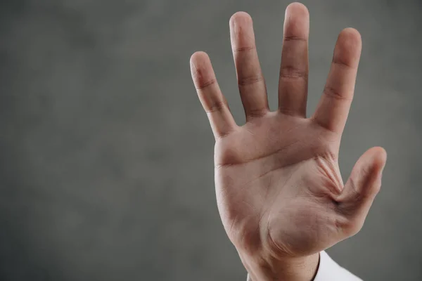 Close-up partial view of human palm on grey — Stock Photo