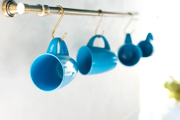 Селективный фокус пустых синих чашек висит на кухне — стоковое фото