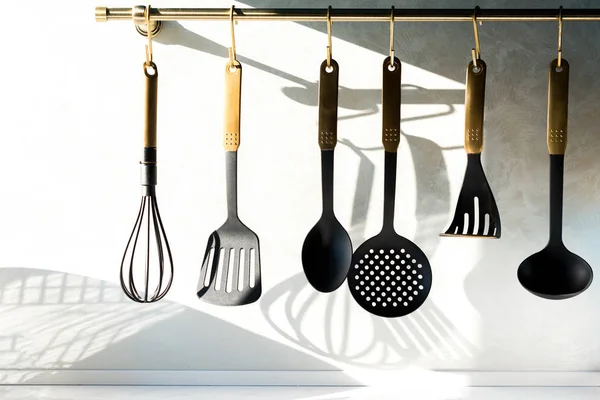Крупный план различных посуда висит на кухне — стоковое фото