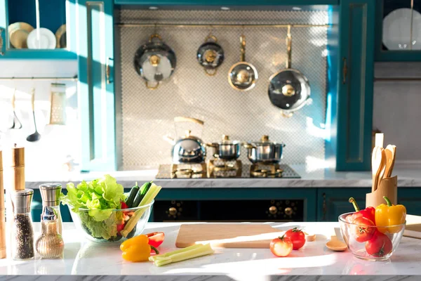 Frisches Gemüse und Gewürze auf dem Tisch in der leeren Küche — Stockfoto