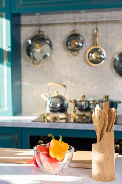 Utensílios de madeira e legumes frescos em tigela na mesa da cozinha — Fotografia de Stock