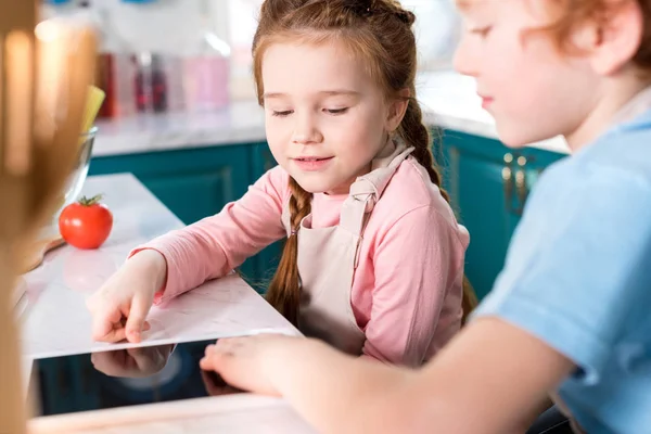 Cropped shot of kids using digital tablet while cooking together — Stock Photo