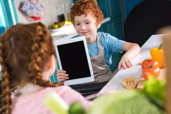 Liebenswerte Kinder mit digitalem Tablet beim gemeinsamen Kochen in der Küche — Stockfoto