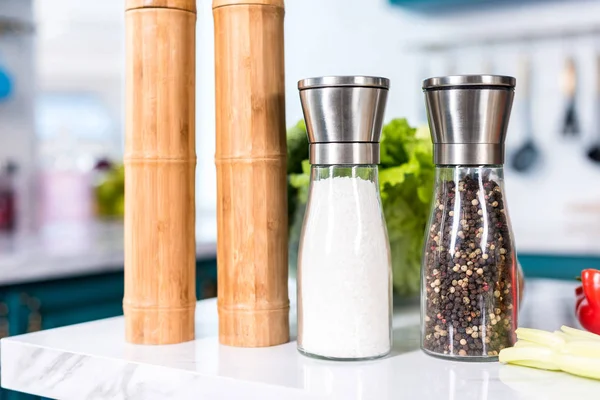 Vista de cerca de las especias en recipientes en la mesa de la cocina - foto de stock