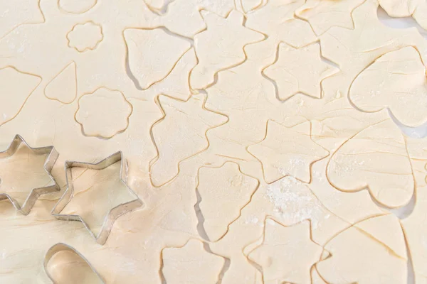 Vue rapprochée de la pâte crue avec différentes formes de biscuits — Photo de stock