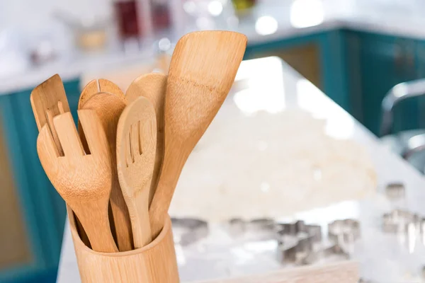 Vista de cerca de los utensilios de madera en contenedor en la cocina - foto de stock