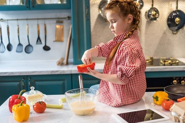 Чарівна маленька дитина готує, сидячи на кухонному столі — стокове фото