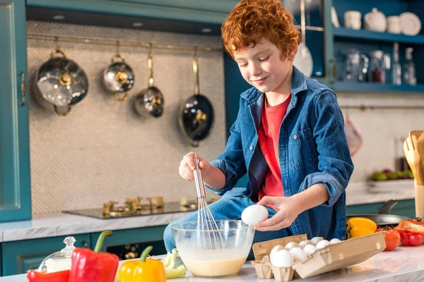 Cute smiling little boy preparing dough in kitchen — Stock Photo