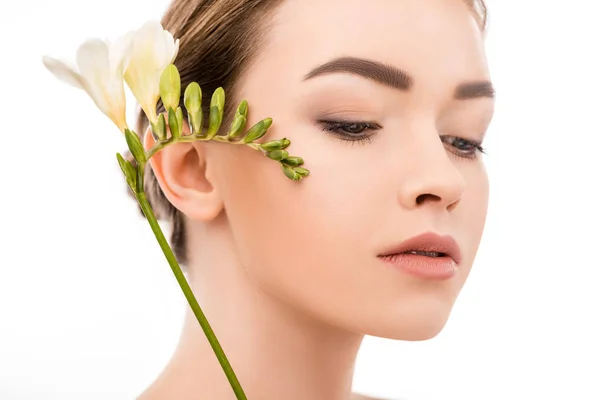 Hermosa chica con la piel limpia celebración flor de la freesia, aislado en blanco - foto de stock