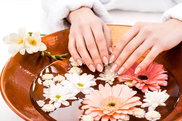 Vista ritagliata della donna che fa procedura spa con fiori nel salone di bellezza, concetto di cura delle unghie — Foto stock