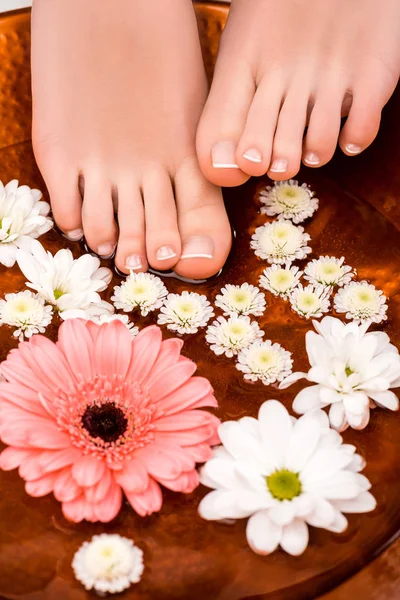 Vue recadrée de femme faisant bain avec des fleurs pour les pieds — Photo de stock