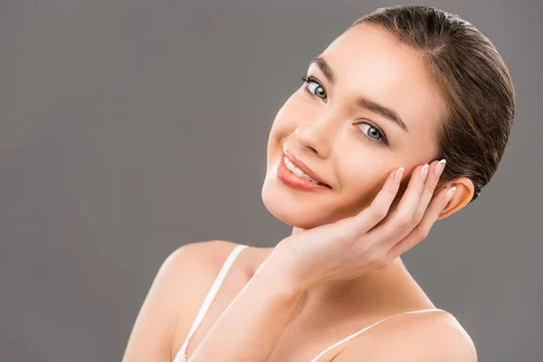 Bella giovane donna sorridente con pelle perfetta, isolata sul grigio — Foto stock