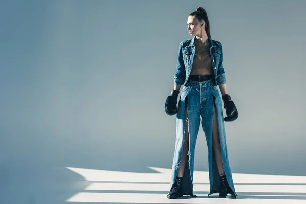 Beautiful model in denim clothes with boxing gloves — Stock Photo