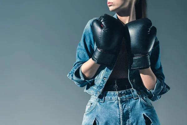 Vista parziale di ragazza alla moda in posa con i guanti da boxe, isolato su grigio — Foto stock