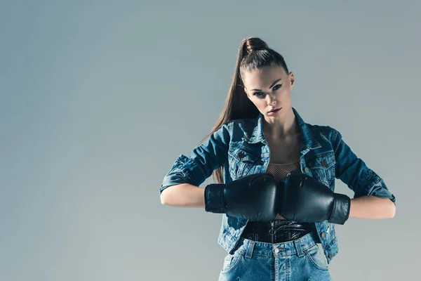 Élégant fille en denim vêtements et gants de boxe, isolé sur gris — Photo de stock