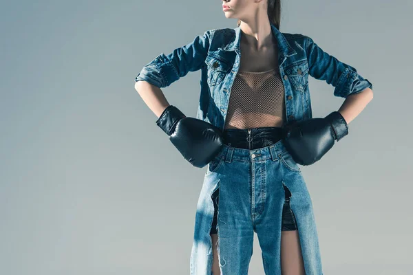 Vue recadrée d'une fille élégante en denim et gants de boxe, isolé sur gris — Photo de stock