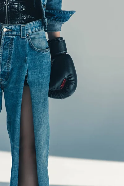 Recortado vista de chica en jeans y guante de boxeo - foto de stock