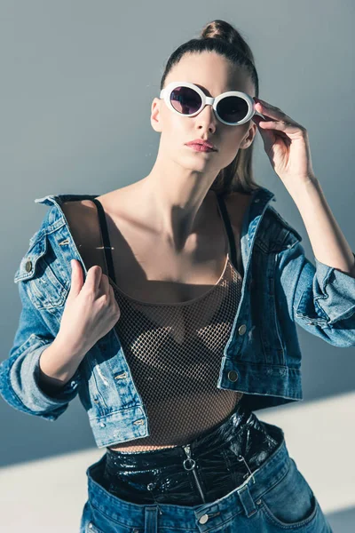 Modelo elegante posando en ropa de mezclilla y gafas de sol — Stock Photo