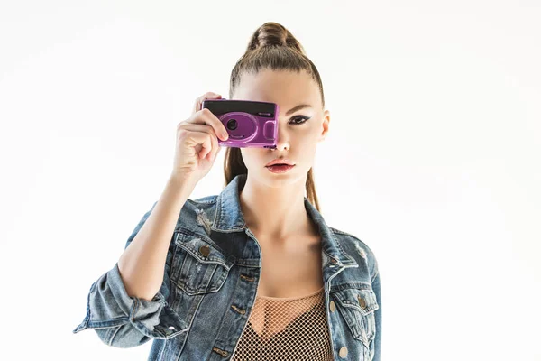 Girl posing in denim clothes with retro camera, isolated on white — Stock Photo