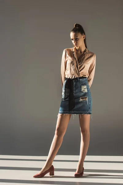 Beautiful stylish girl posing in blouse and denim skirt — Stock Photo