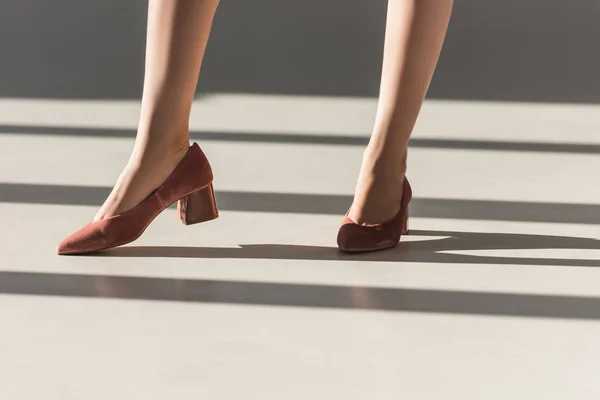 Sección baja de chica de moda posando en zapatos rojos - foto de stock