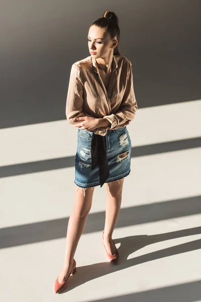 Fashionable girl posing in blouse and denim skirt — Stock Photo