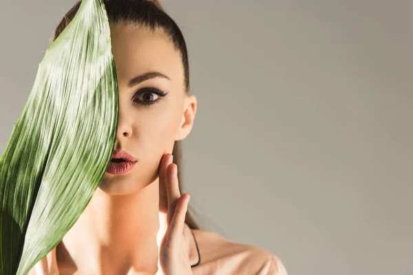 Beautiful girl with green leaf, isolated on grey, skin care concept — Stock Photo