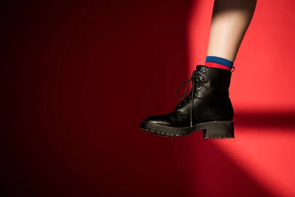 Обрізаний вид жіночої ноги в чорному взутті на червоному — стокове фото