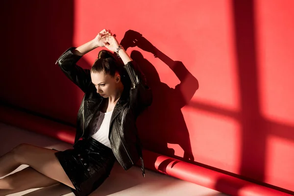 Menina elegante posando em jaqueta de couro preto para tiro de moda no vermelho — Fotografia de Stock