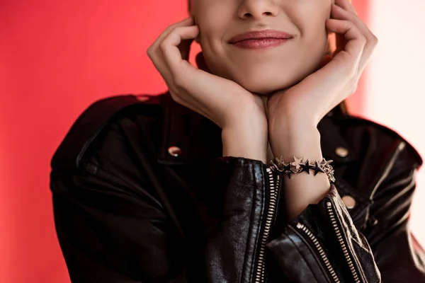 Cropped view of girl in black leather jacket on red — Stock Photo