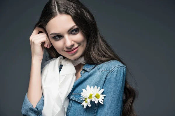 Усміхнена дівчина позує в шарфі і джинсовій сорочці з квітами, ізольована на сірому — стокове фото