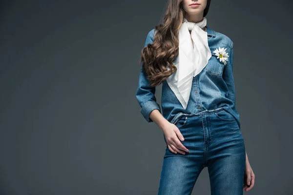 Обрезанный вид девушки с длинными волосами, позирующей в шарфе и джинсовой рубашке с цветами, изолированный на сером — стоковое фото
