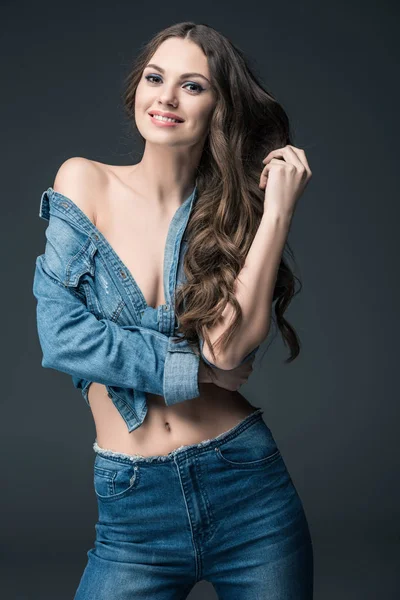 Smiling seductive woman posing in denim shirt, isolated on grey — Stock Photo