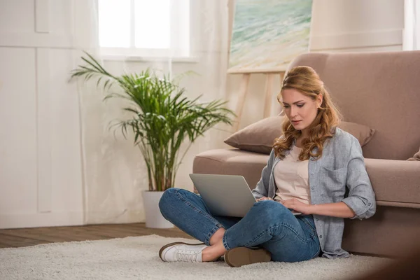 Hermosa mujer joven usando el ordenador portátil en casa - foto de stock