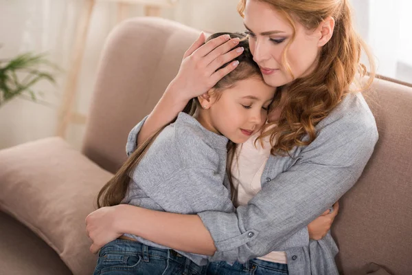 Schöne Mutter und kleine Tochter beim Umarmen zu Hause — Stockfoto