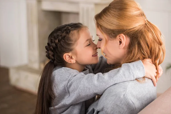 Beautiful happy mother and daughter hugging together at home — Stock Photo