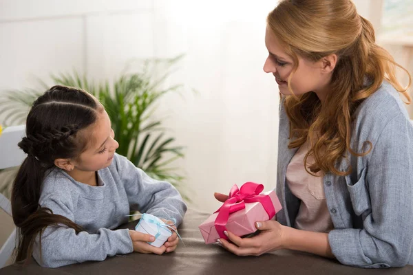 Bela mãe feliz e filha segurando caixas de presente em casa — Fotografia de Stock