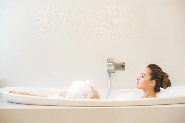 Side view of young beautiful woman taking bath at home — Stock Photo