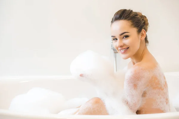 Lächelnde schöne junge Frau badet zu Hause — Stockfoto