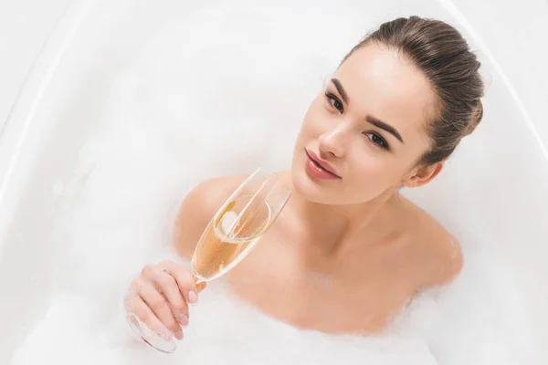 Belle femme avec verre de champagne prenant son bain — Photo de stock