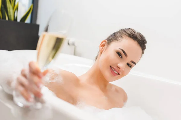 Selektiver Fokus der schönen Frau mit einem Glas Champagner im Bad — Stockfoto