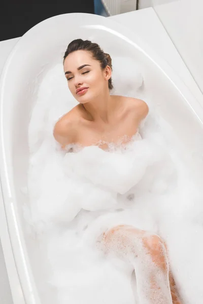 Overhead view of beautiful young woman taking bath at home — Stock Photo